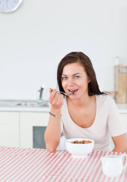 istock Young woman eating cereal 855424600