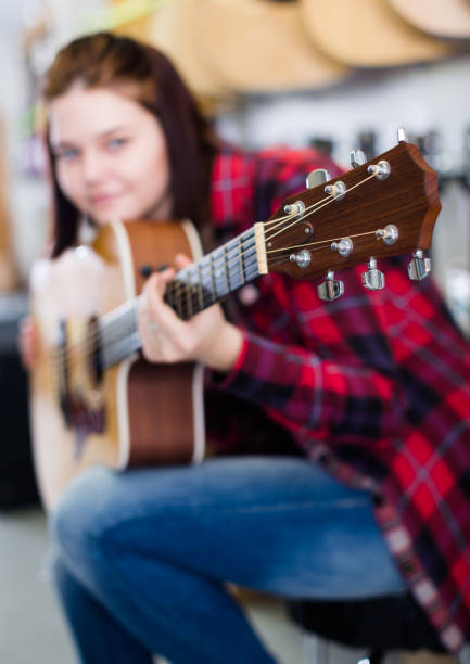 istock Girl is deciding on acoustic guitar 855429672