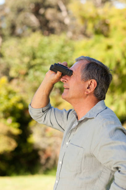 istock Senior man looking at the sky with his binoculars 855432380