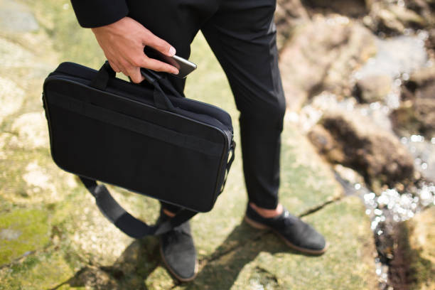 istock Businessman carrying briefcase and phone 855432602