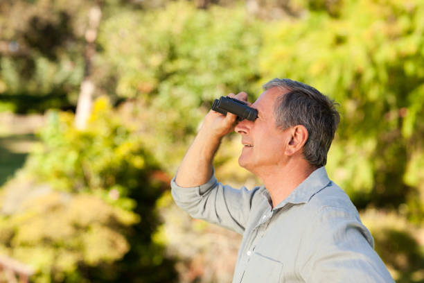 istock Elderly man looking at the sky with his binoculars 855432612