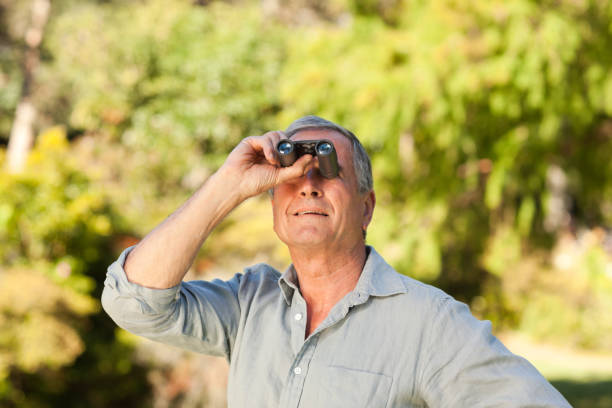 istock Elderly man looking at the sky with his binoculars 855432748