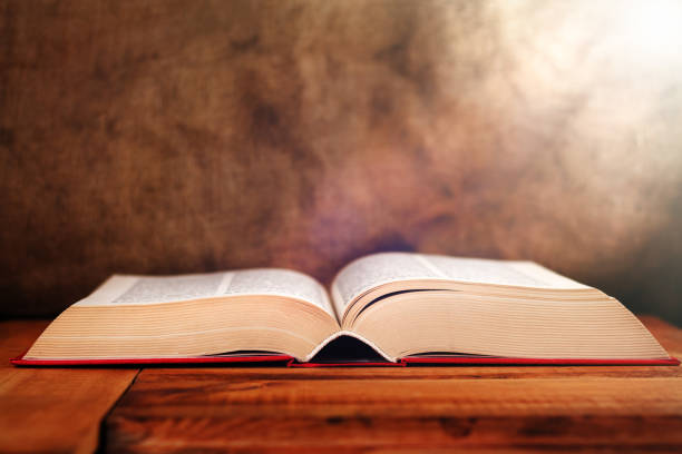istock Old Book with light on old vintage table. Selective focus 855438660
