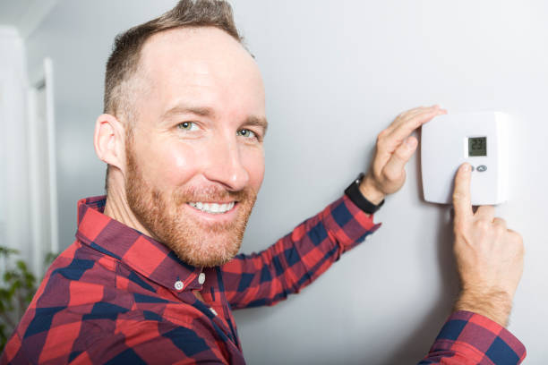 istock men set the thermostat at home 855438762