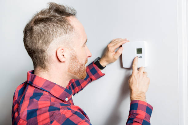istock men set the thermostat at home 855438832
