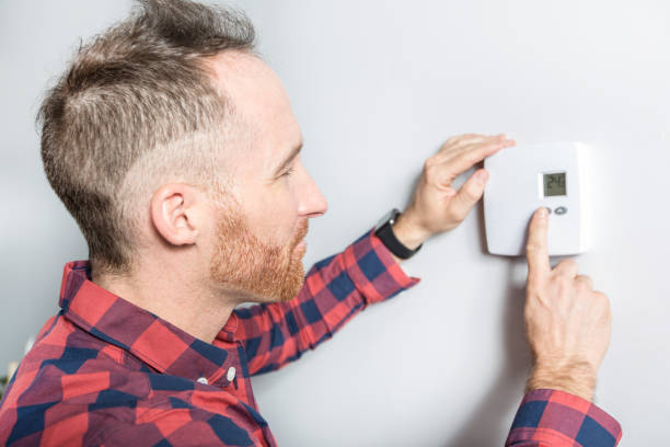 istock men set the thermostat at home 855438880