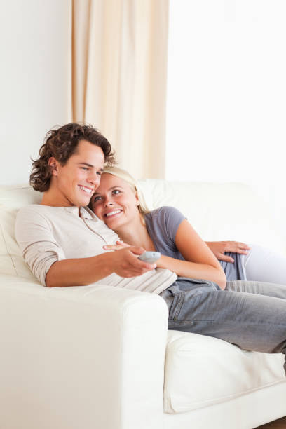 istock Portrait of a cute couple cuddling while watching TV 855439764