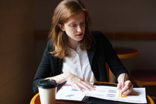 istock Serious businesswoman working with papers at cafe 855442654