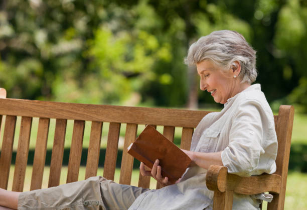 istock Retired woman reading a book on the bench 855442744