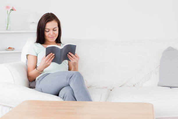 istock Smiling darkhaired woman reading a book 855443108