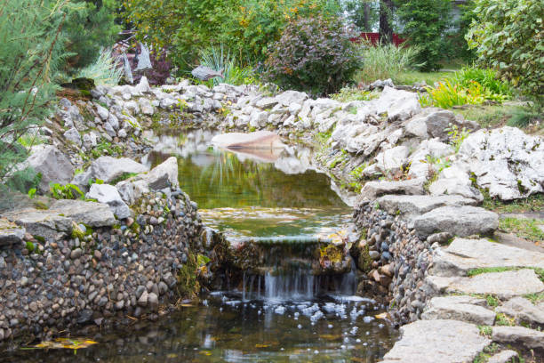 istock Artificial waterfall in the park, cascading down the rocky rocks 855443400