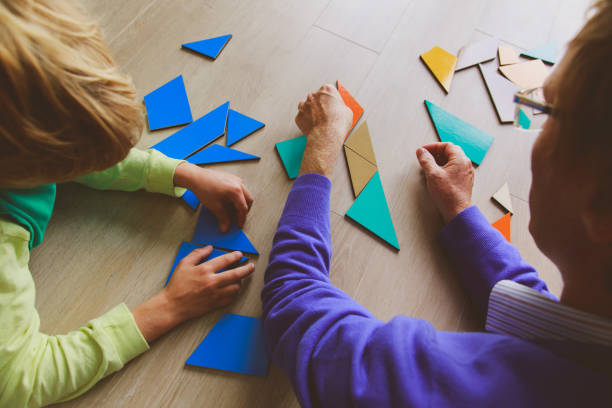 istock teacher and child playing with geometric shapes 855443706