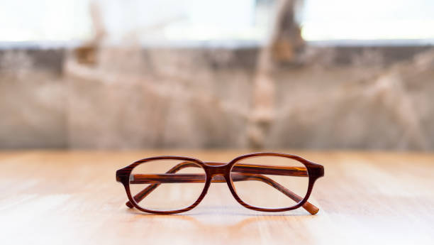 istock close up eyeglasses on wooden table with blur background 855444538