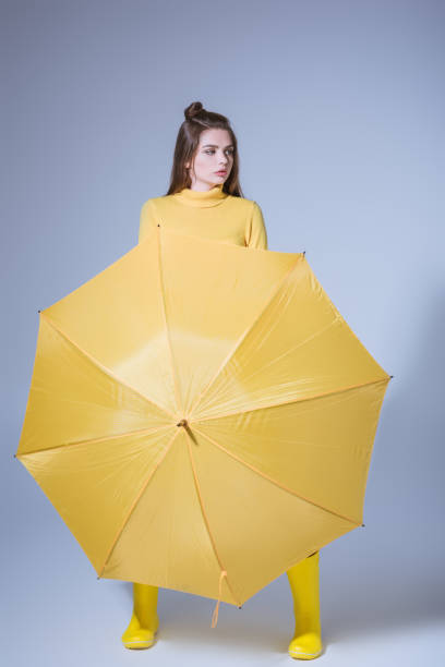 istock girl with yellow umbrella 855445276