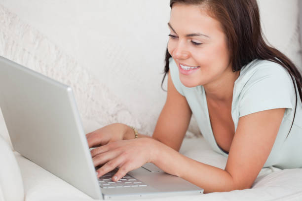 istock Close up of a young woman on a sofa using a laptop 855447284