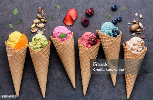 Various Of Ice Cream Flavor In Cones Blueberry Strawberry Pistachio Almond Orange And Cherry Setup On Dark Stone Background Summer And Sweet Menu Concept Stock Photo - Download Image Now