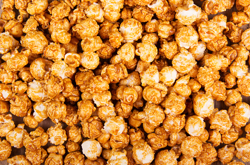 Golden caramel popcorn closeup. Background of popcorn. Snacks and food for a movie