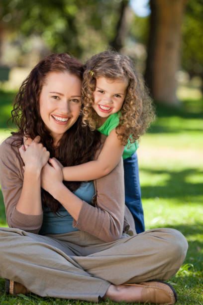 istock Woman hugging her daughter in the park 855451710