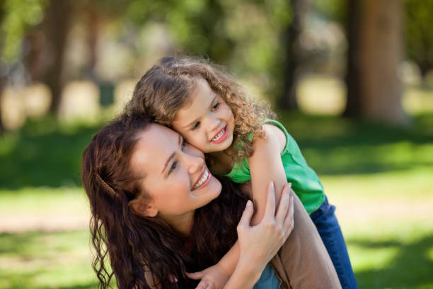 istock Woman hugging her daughter in the park 855451752