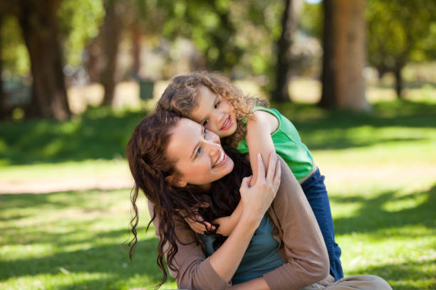 istock Woman hugging her daughter in the park 855451886