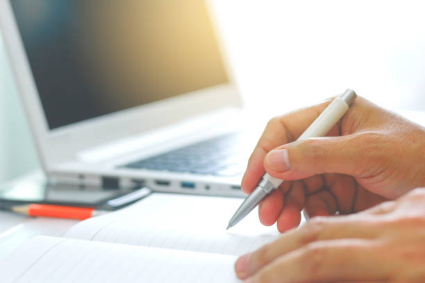 istock Stock Photo - Blurry man's Hands Holding A Pen Writing 855456190