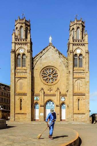 Antananarivo, Madagascar, May 16, 2017: A janitor sweeping in front of the Immaculate Conception Cathedral of Andohalo, upper town of Antananarivo