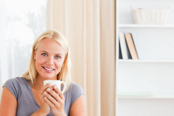 istock Woman sitting on a couch with a cup of tea 855463466