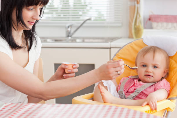istock Attractive brunette woman feeding her baby while sitting 855470976