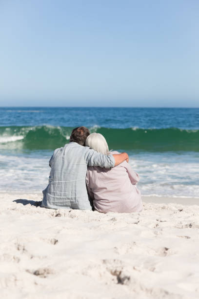 istock Senior couple sitting on the beach 855471508