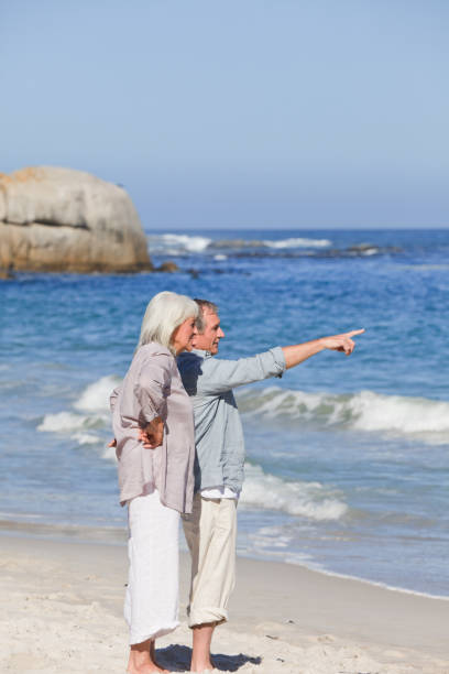 istock Elderly couple walking on the beach 855471982