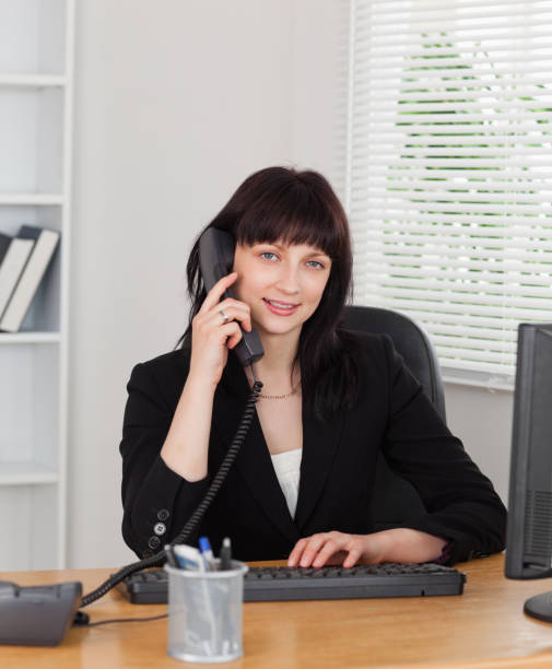 istock Good looking brunette woman on the phone while working on a computer 855475582