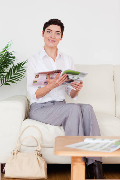 istock Cute woman reading a magazine 855475866