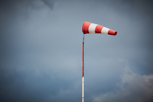 Windsock blown by the wind with overcast sky on background