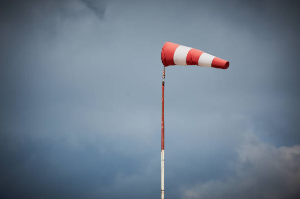 windsock blown by the wind with overcast sky - anemometer meteorology measuring wind imagens e fotografias de stock
