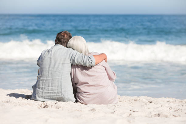 istock Senior couple sitting on the beach 855481780