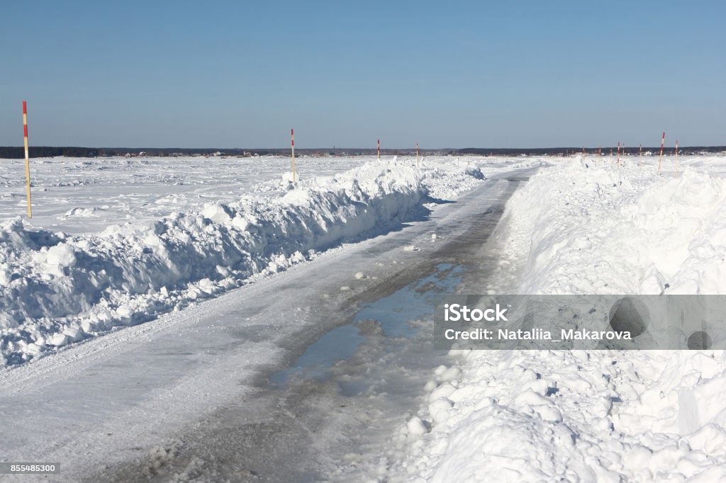 Ice road melting on a frozen reservoir in winter Ice road melting on a frozen reservoir in winter, Ob river, Siberia, Russia Agricultural Field Stock Photo