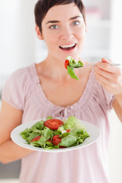 istock Cute woman eating salad 855485650
