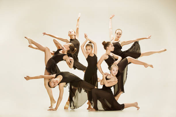 The group of modern ballet dancers The group of modern ballet dancers dancing on gray studio background acrobatic gymnastics stock pictures, royalty-free photos & images