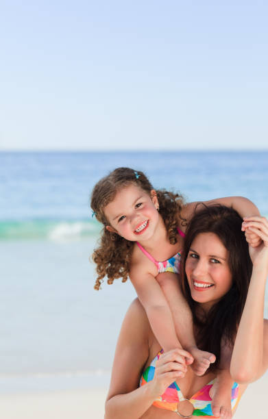 istock Mother playing with her daughter on the beach 855486044