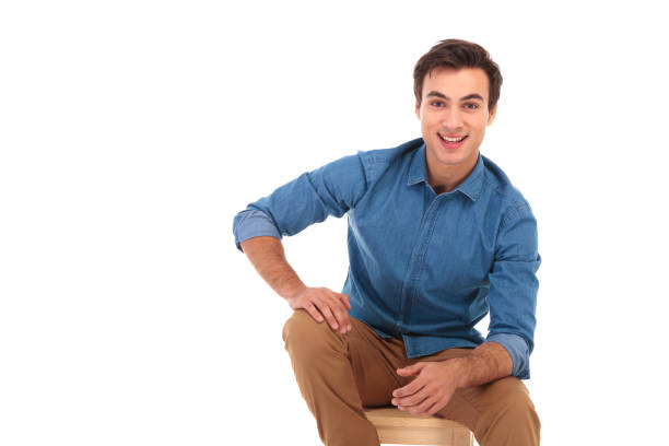 istock attractive young casual man smiling and sitting 855490410