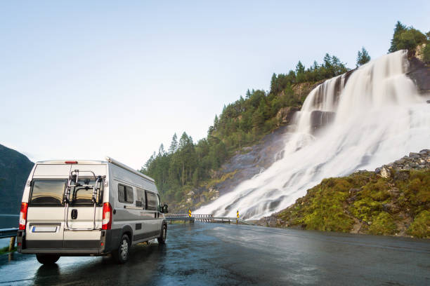 istock Camping van at beautiful huge waterfall. Amazing cataract at road. Norway. 855490448