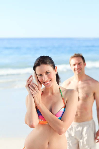 istock Couple listening to their shell 855493456