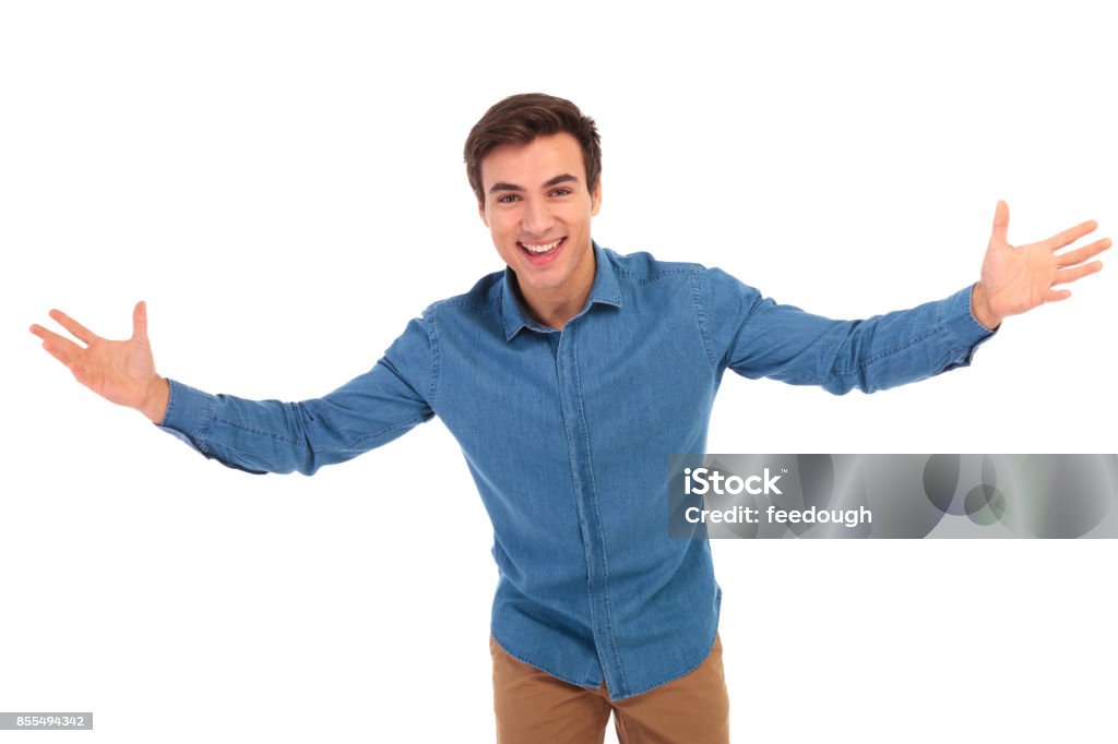 excited young casual man welcoming excited young casual man welcoming you on white background Men Stock Photo