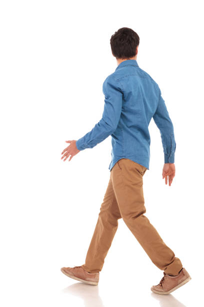 istock rear view of a walking casual man looking to side 855494494