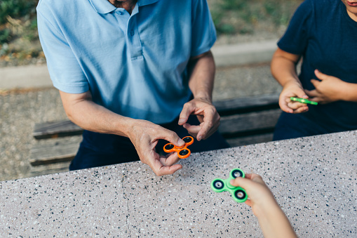 Grandfather learns to play with fidget spinner