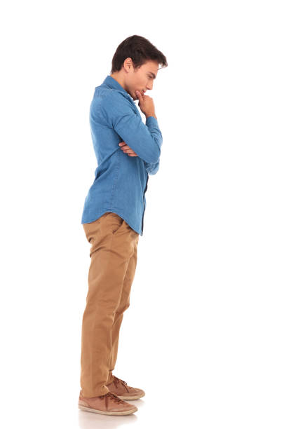 thoughtful young casual man looking down on white background
