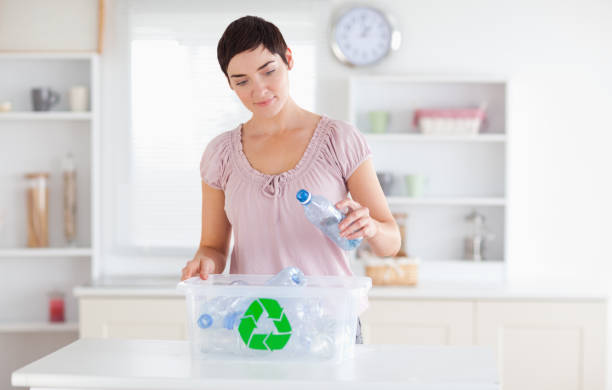 istock Woman putting bottles in a recycling box 855498060