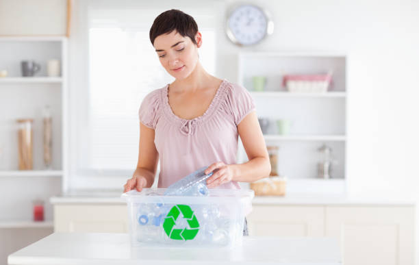 istock Charming Woman putting bottles in a recycling box 855498092