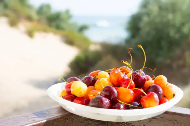 sweet cherry over sand dunes and sea background