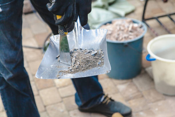 istock employee collects garbage on construction trowel scoop 855504310